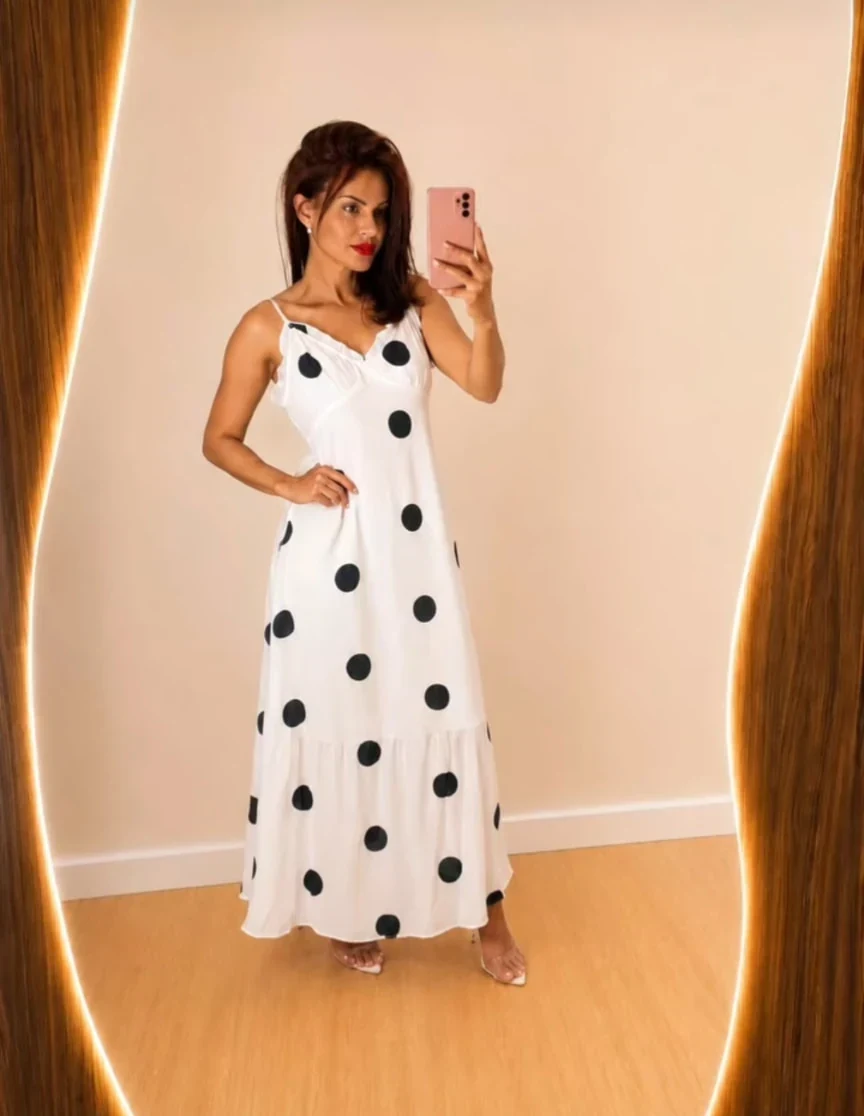 Modelo com vestido longo branco de poás pretos